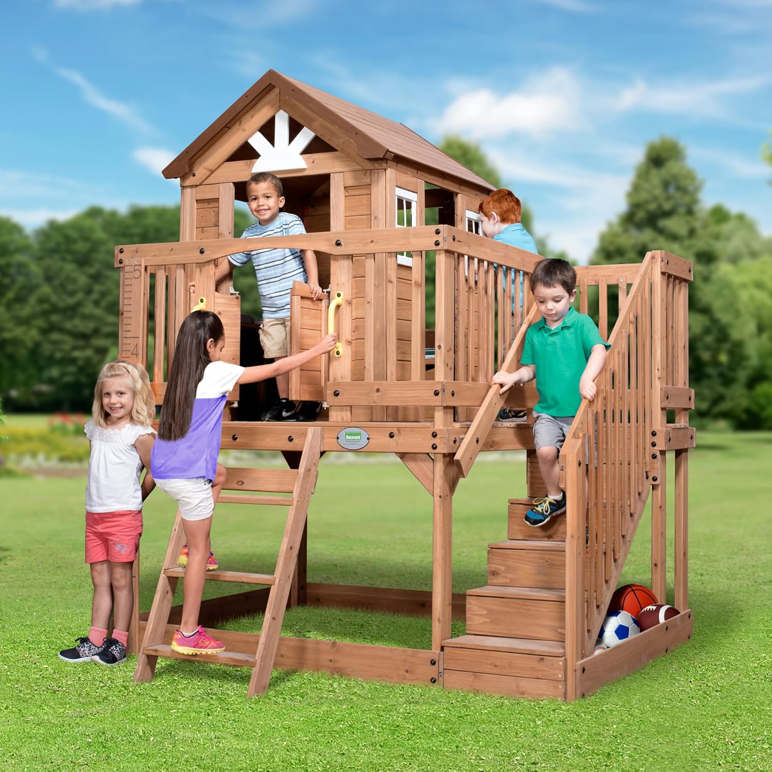 Backyard Discovery Scenic Heights Elevated Cedar Wooden Kids Playhouse with Play Kitchen, Wrap-Around Deck, Toy Storage Bench, Saloon-Style Doors, Ladder, Stairs, and Growth Chart for Outdoor Play